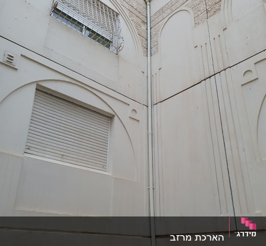 צינור מים חיצוני מחובר לקיר בניין